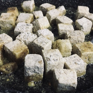 Tofu welches in der Pfanne angebraten wird.