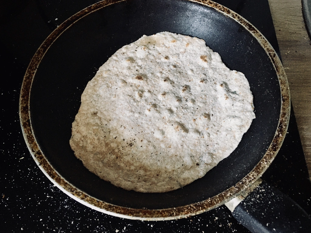 Chapati Brot wird in einer kleinen Pfanne gebacken