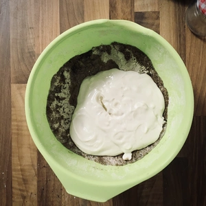 Eine grüne Schale gefüllt mit Mehl und am Rand Fenchel gestreut wurde. In der Mitte befindet sich Joghurt