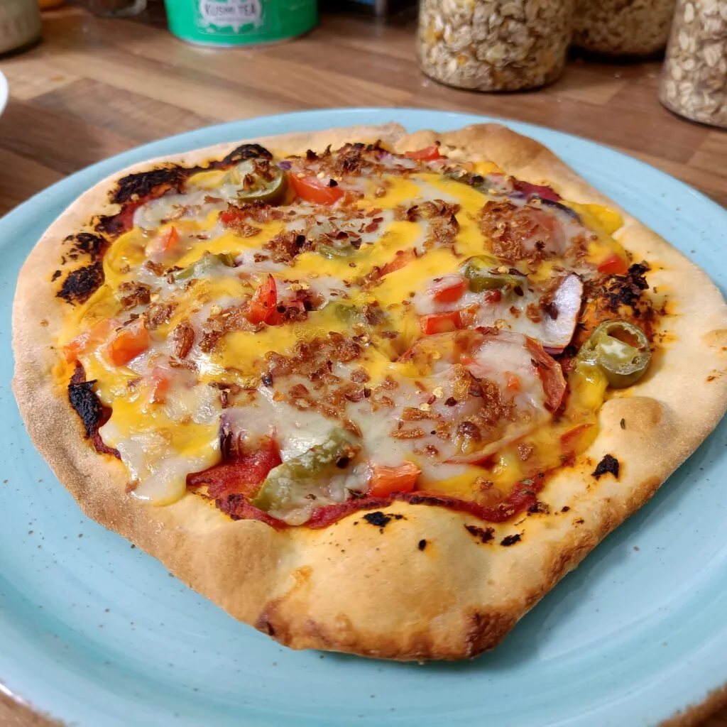 Bild einer Pizza, belegt mit verschiedenen Geüse und zwei sorten geschmolzenen Käse